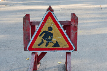 Two road signs on portable stands block the street triangular road works sign round red no entry...