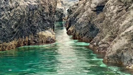 Fototapeta premium Experience the Serene Coastal Passage Nestled Between Majestic Rocky Cliffs and Waves