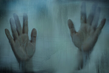 Desperate hand pressed on foggy glass, Blurry Woman behind steamed glass, reaching out with hand,...