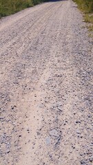 dirt road in the field, gray road with gravel