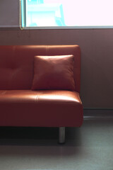 A modern, minimalist living room featuring a sleek red sofa with a single accent cushion, creating a bold, contemporary feel.