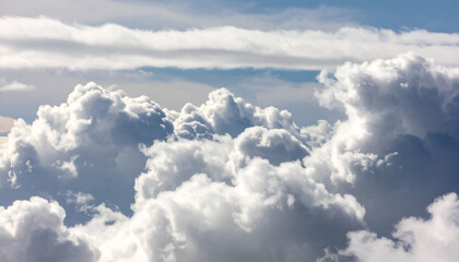 A close-up view of fluffy white clouds filling the vast blue sky, showing detailed textures.