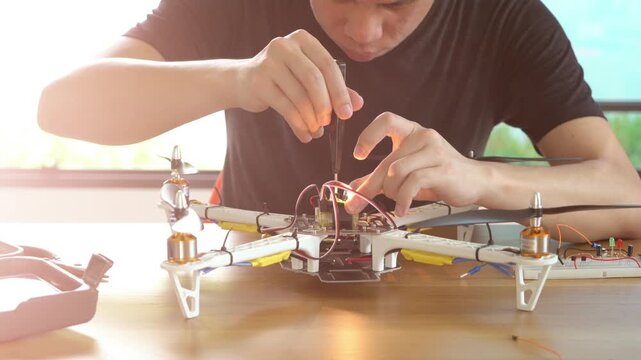 A person focuses on assembling a drone, adjusting its components with precision. This hands-on activity showcases the blend of technology and creativity, highlighting the excitement of building custom