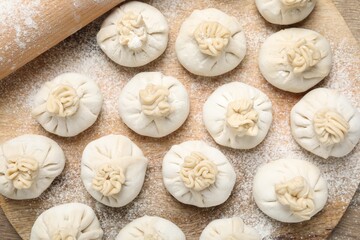 Uncooked khinkalis (dumplings) on table, top view