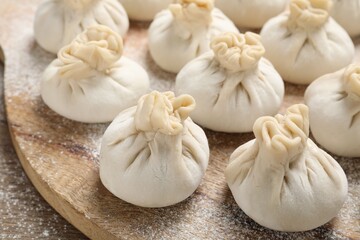 Many uncooked khinkalis (dumplings) on table, closeup