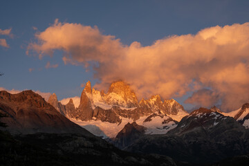 Obraz premium Magical sunrise on Mount Fitz Roy, Patagonia. The snow-capped mountains are bathed in golden light beneath vibrant clouds