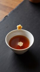 Elegant tea with delicate flower-shaped edible decorations in a white bowl