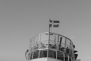 National Sweden flag (Sveriges flagga) blowing open on top of boat in black and white