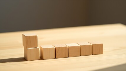 Wooden cube blocks arranged in progression on a smooth table, highlighted by soft natural lighting.