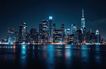 Obraz premium A nighttime view of a modern city skyline illuminated with bright lights reflecting on the water