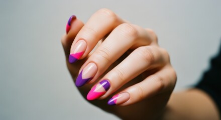Hand displays almond nails with purple & pink geometric nail art