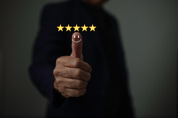 Businessman hand showing thumbs up with five golden stars and smile face symbolizing excellent...