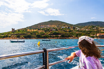 Child watching the coast from boat with Genoese tower France Corsica Sagone 19 June 2025
