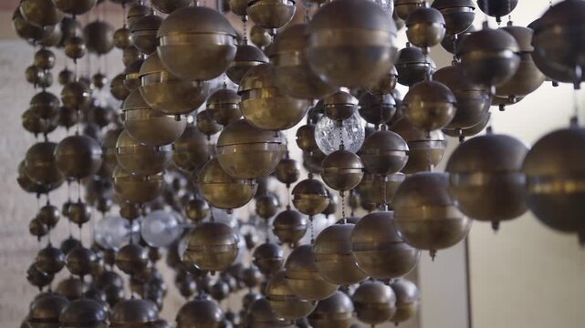 Hanging metallic spheres candelabra light creating an abstract artistic display