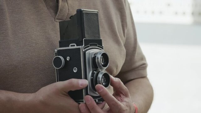 Close-up of photographer person operating vintage retro twin lens reflex camera