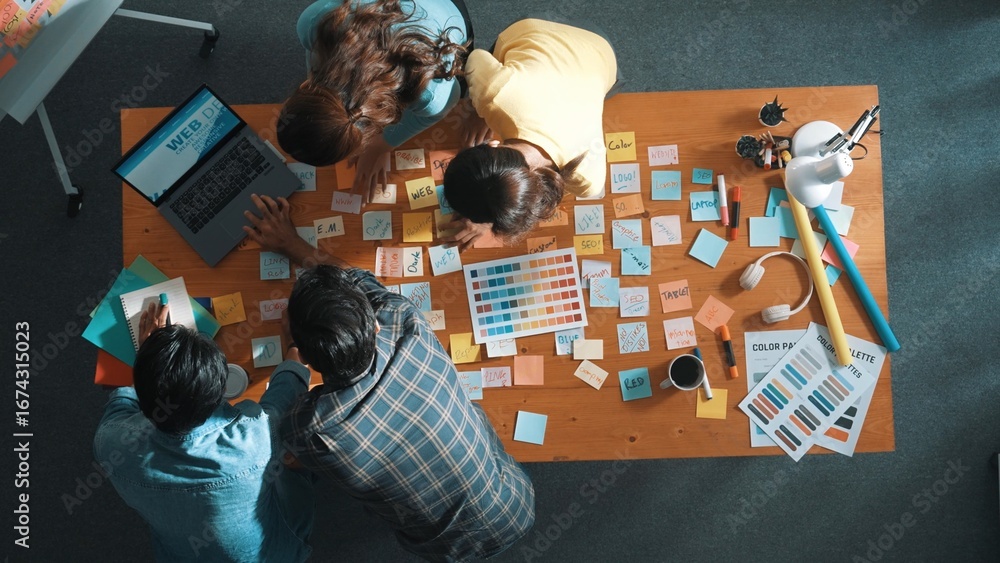 Aufkleber top down view of business team with casual outfit looking laptop screen and sharing idea. aerial vie