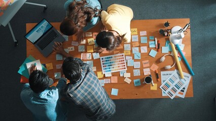 Top down view of business team with casual outfit looking laptop screen and sharing idea. Aerial...
