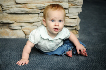 Fototapeta premium Cute Baby Sitting on Carpet Floor in Home