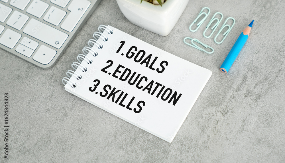Poster a notebook with the words goals education and skills written on it. the notebook is placed on a desk