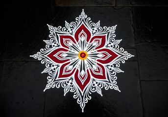 White and red alpana design on temple floor