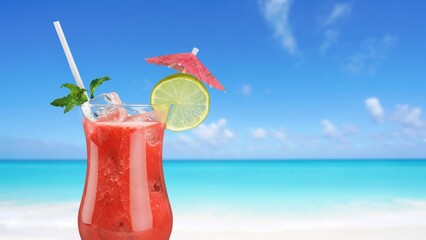 Cold cocktail in glass with beach on background