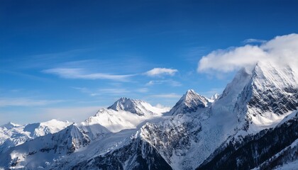 majestic snow capped mountains rise against a clear blue sky enveloped in wispy clouds creating a serene winter landscape