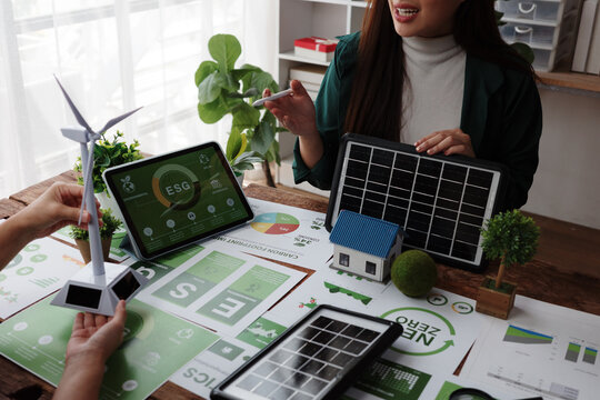 Business team discussing renewable energy solutions with solar panels - Powered by Adobe