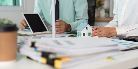 Sustainability Planning: Professionals Collaborating on Eco-Friendly Housing Project