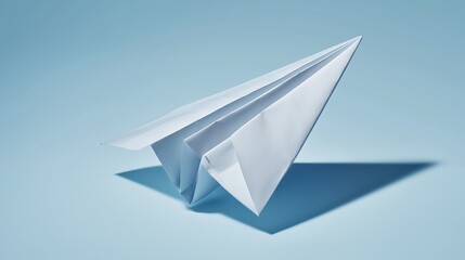 Paper airplane flying against blue sky background