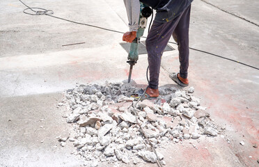 Worker demolish existing concrete road by jack hammer for repair concrete floor. Surface road...