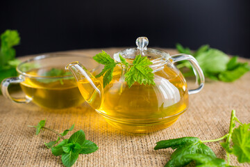 Green tea with currant leaves and mint in glass teapot and cup