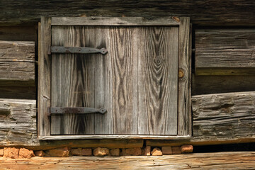 Wooden shutters on a log-framed barn