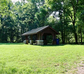 The wood picnic shelter in the park on a sunny day.