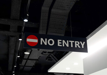 No entry sign hanging from ceiling in modern building with industrial design and bright lighting features