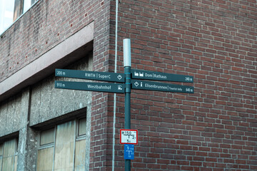 German street signpost with directions to cathedral, station, and tourist sites