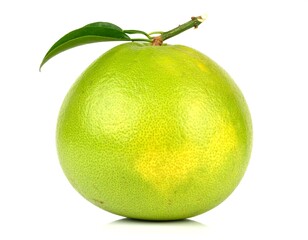 Fresh pomelo fruit resting with vibrant green skin and small leaf on white surface