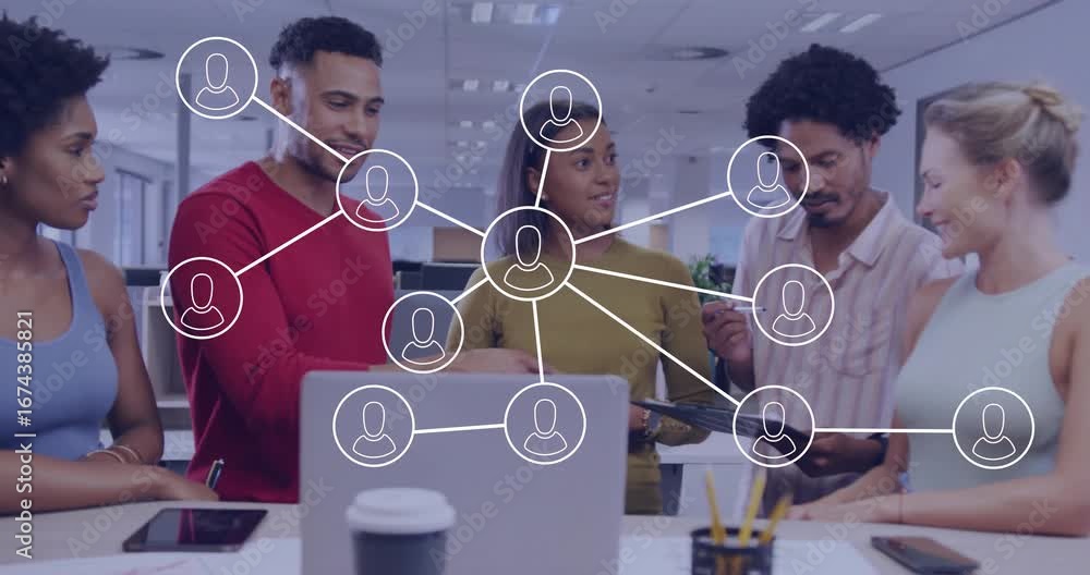 Poster man in red gesturing activating network diagram over laptop while tech team reviewing connections