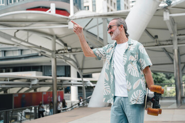 Happy senior man riding electric skateboard in city, enjoying urban lifestyle, freedom, and active aging. Modern elderly embracing technology and outdoor activity with headphones and relaxed clothing.