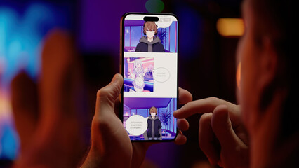 Reading colored maid girls digital manhwa comic webtoon on smartphone with RGB PC in background,...