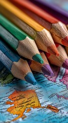 Colorful Pencils Arranged Over a Vintage World Map Showcasing Vibrant Hues and Geographical Details.