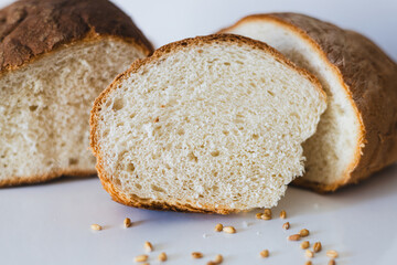 Freshly baked bread with crusty top and soft interior showcased on a flat surface with scattered seeds in a kitchen setting