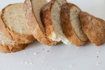 Freshly baked artisanal bread slices arranged neatly on a countertop ready for a delicious meal or...