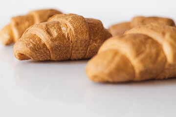 Freshly baked croissants arranged neatly on a smooth surface in a bright kitchen setting during the morning hours