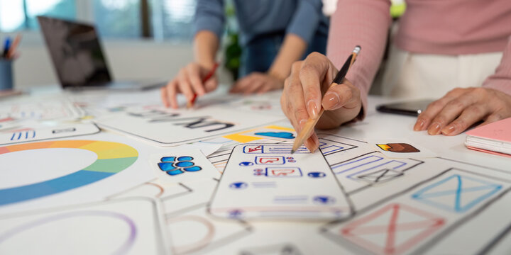 Hands on UX and UI Design. Team members sketching ideas and wireframes on a collaborative project.