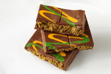 Dubai pistachio chocolate. Chocolate bars decorated with green and yellow swirls on white background