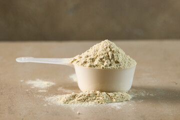 protein powder in scoop. dry mixture for preparation of sporting or dietary drink.