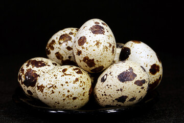Quail eggs on black background, close-up shot