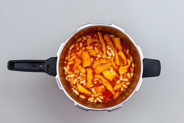 A classic Brazilian dish known as dobradinha, prepared with beef tripe, white beans, and tropical spices, served with traditional farofa made from toasted cassava flour.