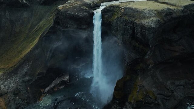 Drone footage of Haifoss waterfall in Iceland canyon. 4K video capturing dramatic drop of river into rocky gorge.