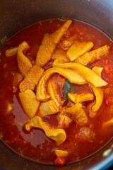 A classic Brazilian dish known as dobradinha, prepared with beef tripe, white beans, and tropical spices, served with traditional farofa made from toasted cassava flour.